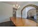 Elegant dining room boasts dark wood floors, stone archway, and a chandelier that enhances the ambiance at 113 Gold Bridge Xing, Canton, GA 30114