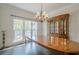 Dining room boasts dark wood floors, a hutch, and a chandelier with bright windows at 113 Gold Bridge Xing, Canton, GA 30114
