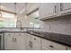 Kitchen features white cabinets, granite countertops, subway tile backsplash, and stainless steel appliances at 113 Gold Bridge Xing, Canton, GA 30114