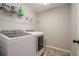 This is a small laundry room with a washer and dryer and wire rack for supplies at 113 Gold Bridge Xing, Canton, GA 30114