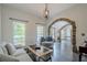 Bright living room featuring a stone archway, hardwood floors, and lots of natural light from large windows at 113 Gold Bridge Xing, Canton, GA 30114