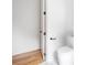 Bright bathroom with a white toilet, an open door, and hardwood flooring outside the bathroom at 1554 Columbia Cir, Decatur, GA 30032