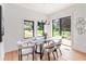 Bright dining room with modern chandelier, sleek table, and views of the green yard at 1554 Columbia Cir, Decatur, GA 30032