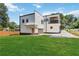 Two-story home with modern design, a balcony, a spacious lawn, and a driveway on a sunny day at 1554 Columbia Cir, Decatur, GA 30032