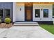 Close up of the wooden front door with light fixtures, gray and white siding, and concrete steps at 1554 Columbia Cir, Decatur, GA 30032
