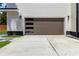 Modern garage door with glass panel windows, plus a large concrete driveway and stylish exterior lighting at 1554 Columbia Cir, Decatur, GA 30032
