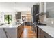 Open kitchen design with stainless steel appliances, wooden cabinets, marble countertops, hardwood floors and a large island at 1554 Columbia Cir, Decatur, GA 30032