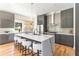 Bright kitchen featuring gray cabinetry, marble countertops and backsplash, stainless steel appliances, and a large island at 1554 Columbia Cir, Decatur, GA 30032