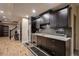 Finished basement bar with granite counters, dark wood cabinets, beverage fridge, built in microwave and tile backsplash at 1984 Mendenhall Cir, Atlanta, GA 30341