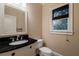 Cozy bathroom featuring a granite countertop, decorative mirror, and window with stylish blinds at 1984 Mendenhall Cir, Atlanta, GA 30341