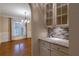 Butler pantry features granite counters, mosaic backsplash, and white cabinets, with an open view to dining room at 1984 Mendenhall Cir, Atlanta, GA 30341