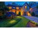 Exterior view of a two-story brick home with a stone facade and a well-manicured lawn, lit up at night at 1984 Mendenhall Cir, Atlanta, GA 30341