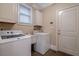 Efficient laundry room with front-loading washer and dryer, utility sink, and storage cabinet at 1984 Mendenhall Cir, Atlanta, GA 30341