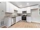 Modern kitchen with white cabinets, granite countertops, stainless steel appliances, and wood-look flooring at 340 Bell Se St, Marietta, GA 30060