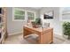 Home office featuring a large wooden desk, built-in bookshelves, and natural light from multiple windows at 340 Bell Se St, Marietta, GA 30060