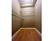 This is a walk in closet with two shelves and wood flooring at 645 Robin Rd, Covington, GA 30016