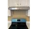 Close-up of stainless-steel range hood with electric range underneath at 645 Robin Rd, Covington, GA 30016