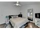A well-lit bedroom featuring a cozy bed, full-length mirror, and ceiling fan at 1133 Capital Club Ne Cir, Brookhaven, GA 30319