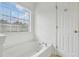 Bright bathroom with a soaking tub next to a window at 5126 Wellsley Bnd, Alpharetta, GA 30005