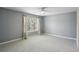 Spacious bedroom featuring plush carpeting, ceiling fan and a sunlit window at 5126 Wellsley Bnd, Alpharetta, GA 30005