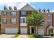 Three-story brick townhome with a two-car garage and front door at 5126 Wellsley Bnd, Alpharetta, GA 30005