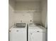 Laundry room with a white Maytag washer and dryer and wire shelving at 5126 Wellsley Bnd, Alpharetta, GA 30005