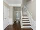 Foyer with wooden staircase and wainscoting detail at 5126 Wellsley Bnd, Alpharetta, GA 30005
