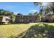 Large backyard with mature trees behind the brick home with patio and carport at 863 Needle Rock Dr, Stonecrest, GA 30083