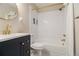 Modern bathroom features a black vanity, gold fixtures, and shower over tub at 863 Needle Rock Dr, Stonecrest, GA 30083
