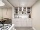 Basement kitchen features white appliances, countertops, and cabinetry at 863 Needle Rock Dr, Stonecrest, GA 30083