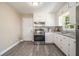 Modern kitchen with white cabinets, stainless steel appliances, and gray backsplash at 863 Needle Rock Dr, Stonecrest, GA 30083