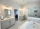Spa-like bathroom with a soaking tub, glass-enclosed shower, double vanities, and marble accents at 306 Coppergate Ct, Holly Springs, GA 30115