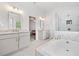 Bright bathroom with marble tile, soaking tub and glass enclosed shower at 306 Coppergate Ct, Holly Springs, GA 30115