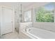 Beautiful bathroom featuring a soaking tub, glass shower, and bright window at 306 Coppergate Ct, Holly Springs, GA 30115