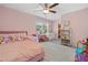Cozy pink bedroom with ceiling fan, plush carpet and large window with blinds at 306 Coppergate Ct, Holly Springs, GA 30115