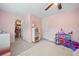 Bedroom with pink walls, plush carpet, and bright natural light from a window at 306 Coppergate Ct, Holly Springs, GA 30115