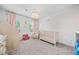 Charming Bedroom featuring a crib, chandelier, pink curtains, and whimsical decor at 306 Coppergate Ct, Holly Springs, GA 30115