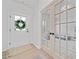 Bright foyer with hardwood floors, glass paneled office doors and the front door with decorative window wreath at 306 Coppergate Ct, Holly Springs, GA 30115