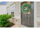 Close-up of a stylish gray front door adorned with a green wreath, set against a backdrop of brick and siding at 306 Coppergate Ct, Holly Springs, GA 30115