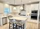 Bright kitchen features white cabinetry, stainless steel appliances, a central island with seating, and pendant lighting at 306 Coppergate Ct, Holly Springs, GA 30115