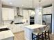 Well-lit kitchen showcasing stainless steel appliances, a center island with seating, and sleek white cabinetry at 306 Coppergate Ct, Holly Springs, GA 30115