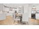 Open kitchen featuring white cabinets, stainless steel appliances, pendant lighting, and a dining area at 306 Coppergate Ct, Holly Springs, GA 30115