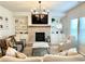 Inviting living room featuring a brick fireplace, built-in bookshelves, neutral furniture, and natural light at 306 Coppergate Ct, Holly Springs, GA 30115