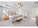 Spacious main bedroom featuring tray ceilings, plush carpet, neutral paint, and an ensuite bathroom at 306 Coppergate Ct, Holly Springs, GA 30115