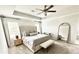 Serene main bedroom with a tufted headboard, neutral tones, tray ceiling, and a seating area with a mirror at 306 Coppergate Ct, Holly Springs, GA 30115