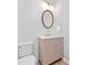 Elegant powder room featuring a modern vanity with marble countertop, oval mirror and gold lighting and fixtures at 306 Coppergate Ct, Holly Springs, GA 30115