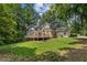 Expansive backyard features a deck, lush green lawn, and mature trees, creating a serene outdoor setting at 3878 Brookside Pkwy, Decatur, GA 30034