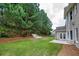 A sprawling backyard with manicured lawn, mature trees, and privacy fence at 5635 Upper Creek Ct, Suwanee, GA 30024