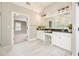Bright bathroom features double sink vanity, black granite countertop, a large mirror, and sleek lighting fixtures at 5635 Upper Creek Ct, Suwanee, GA 30024
