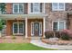 Charming front porch with stone accents, columns, and an elegant front door, surrounded by manicured landscaping at 5635 Upper Creek Ct, Suwanee, GA 30024